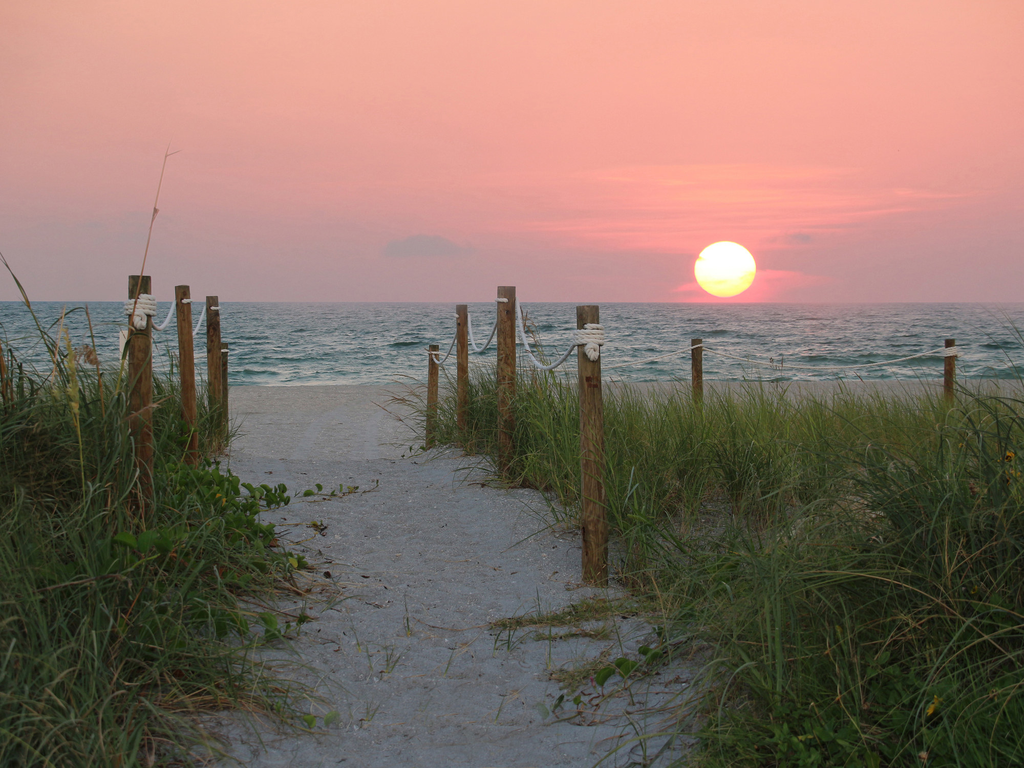a beautiful sunset and pathway to the beach