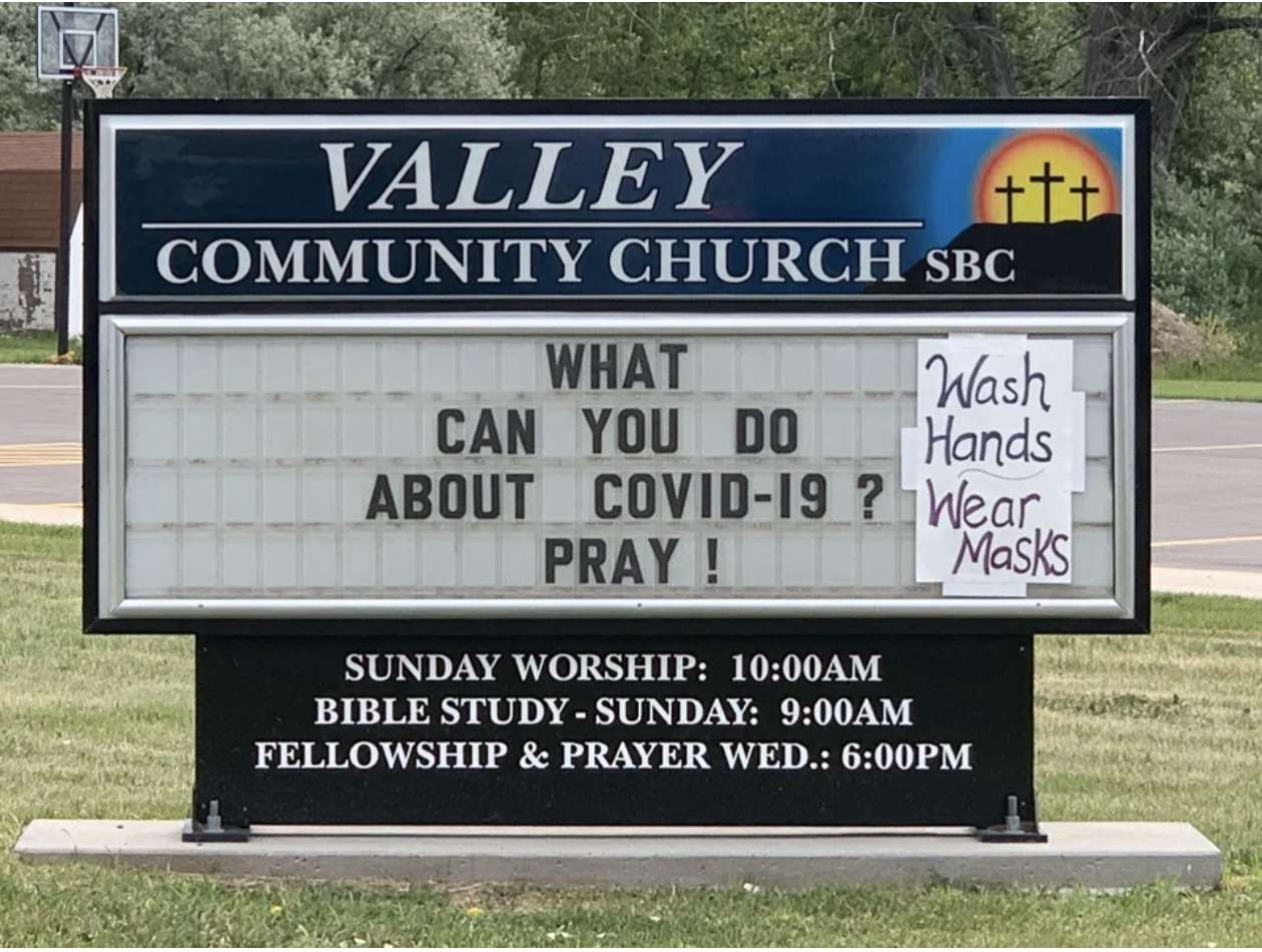 A church sign reading: "What can you do about COVID-19, pray" has "wash hands, wear masks" written on it