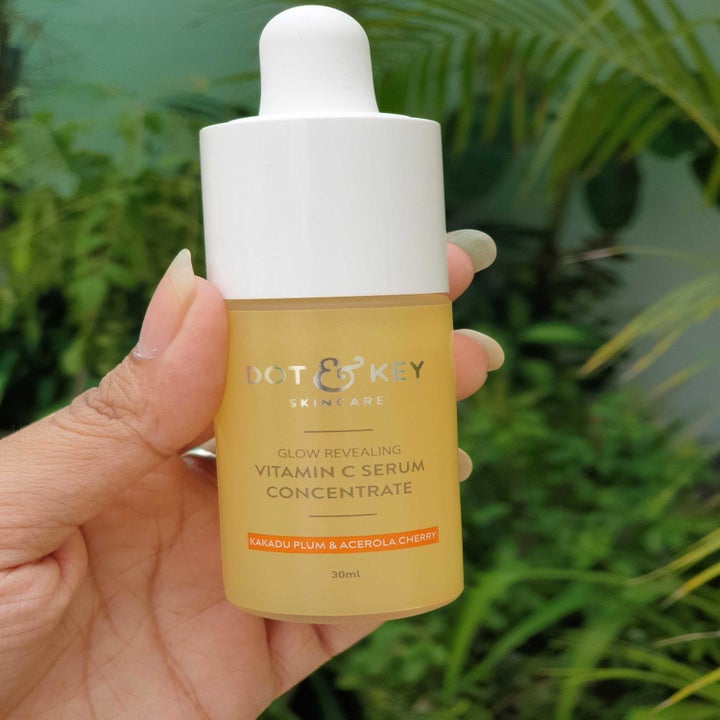 A hand holding the serum bottle.