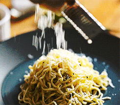 Cheese grated on a plate of spaghetti.