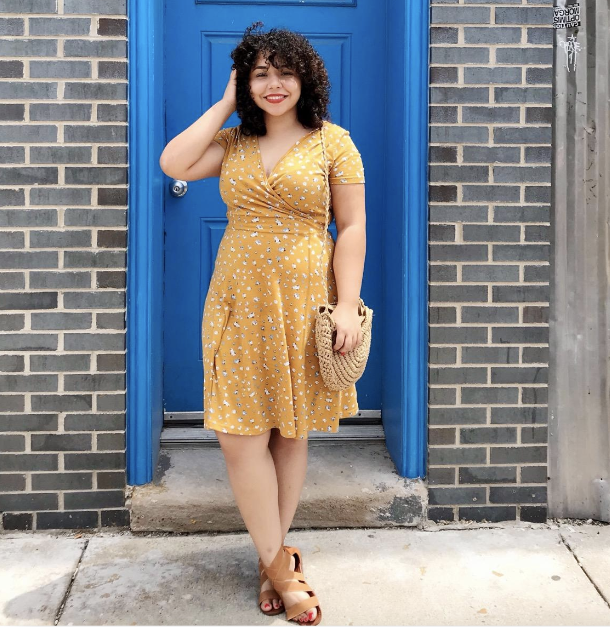 reviewer wearing the yellow floral mini dress