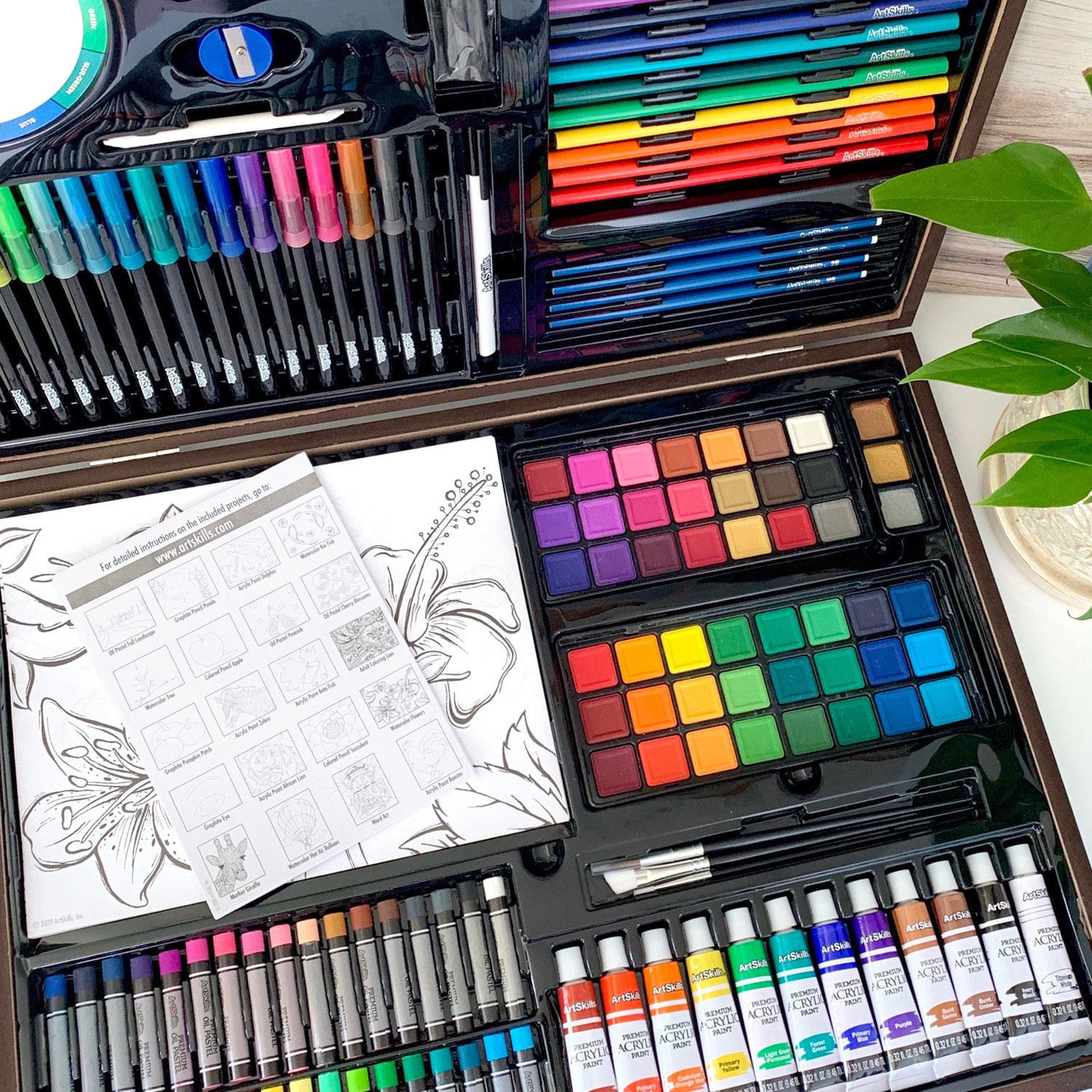Top down shot of art kit showing colorful paints and drawings inside