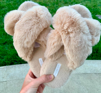 A customer review photo of a person holding the slippers