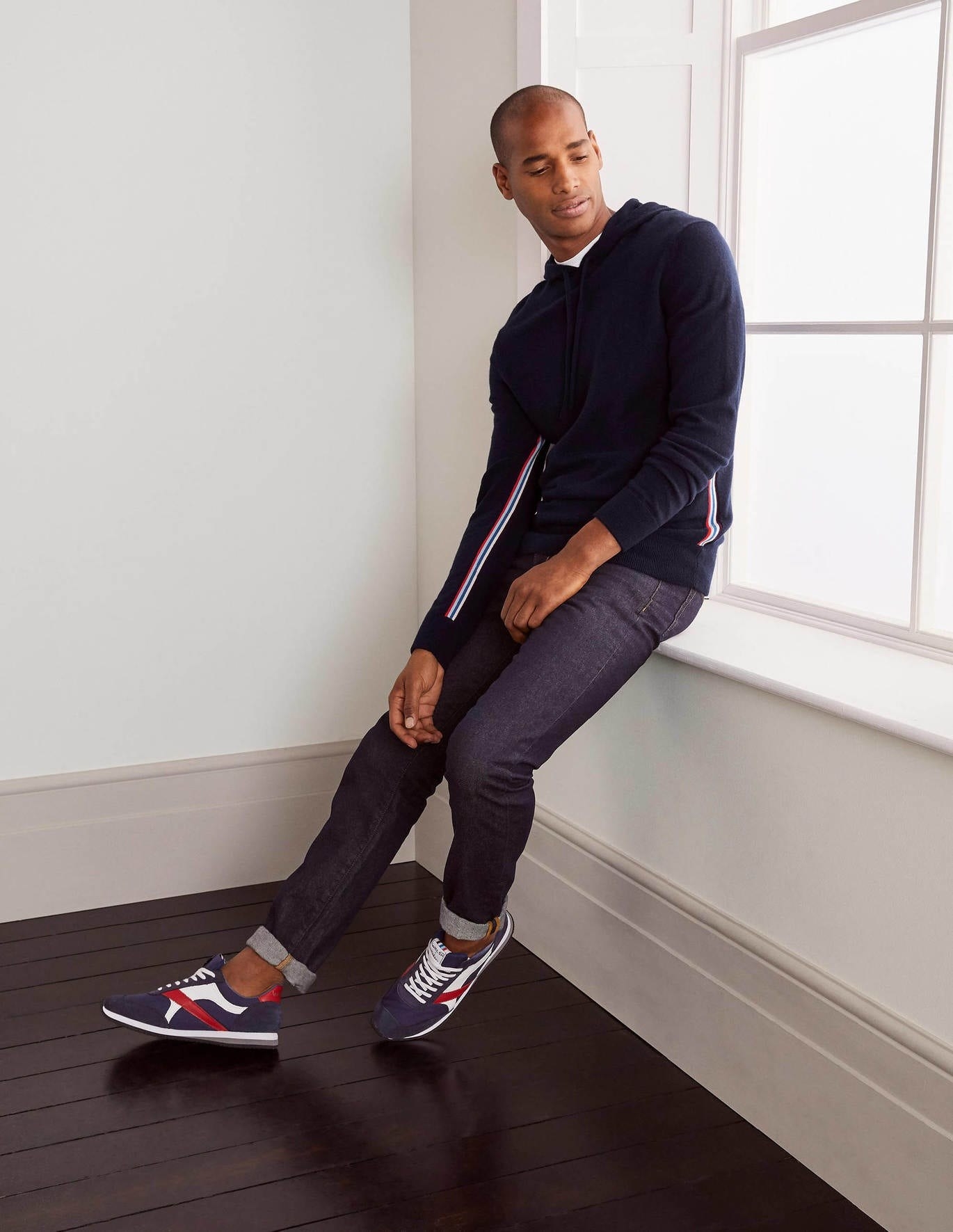 A model in the navy hoodie with red, white and blue stripes down the sleeves