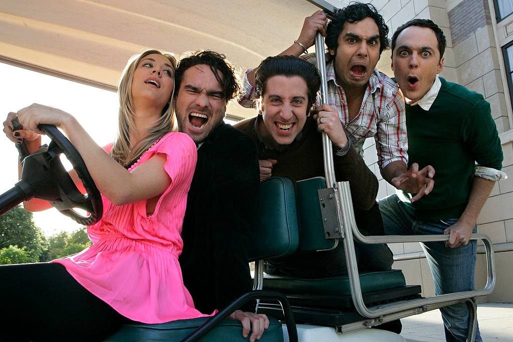 Actors Kaley Cuoco, Johnny Galecki, Simon Helberg, Kumal Nayyar, and Jim Parsons posing in a golf cart