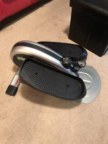 Reviewer pic of the small portable elliptical with black petals on each side that fit a foot