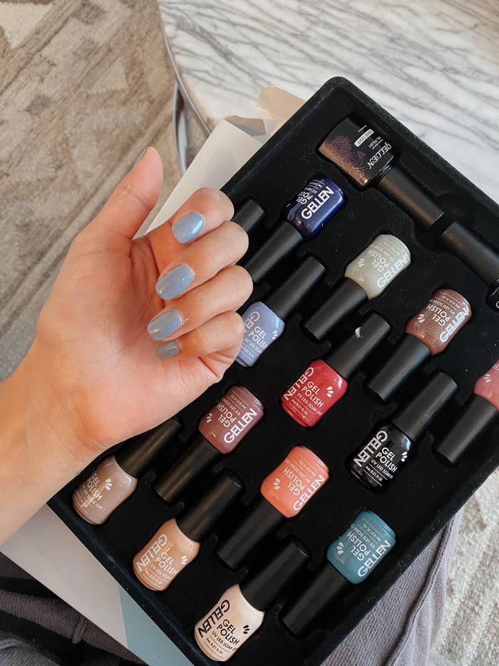A reviewer photo with their nails painted using the gel nail polish and all of the different nail polish colors in the kit