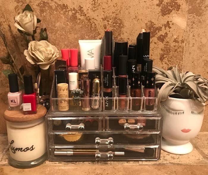 BuzzFeed editor&#x27;s makeup organizer on a bathroom countertop neatly holding various makeup products 
