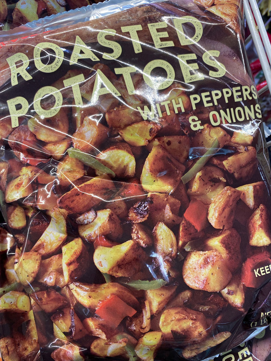 A bag of roasted potatoes with peppers and onions