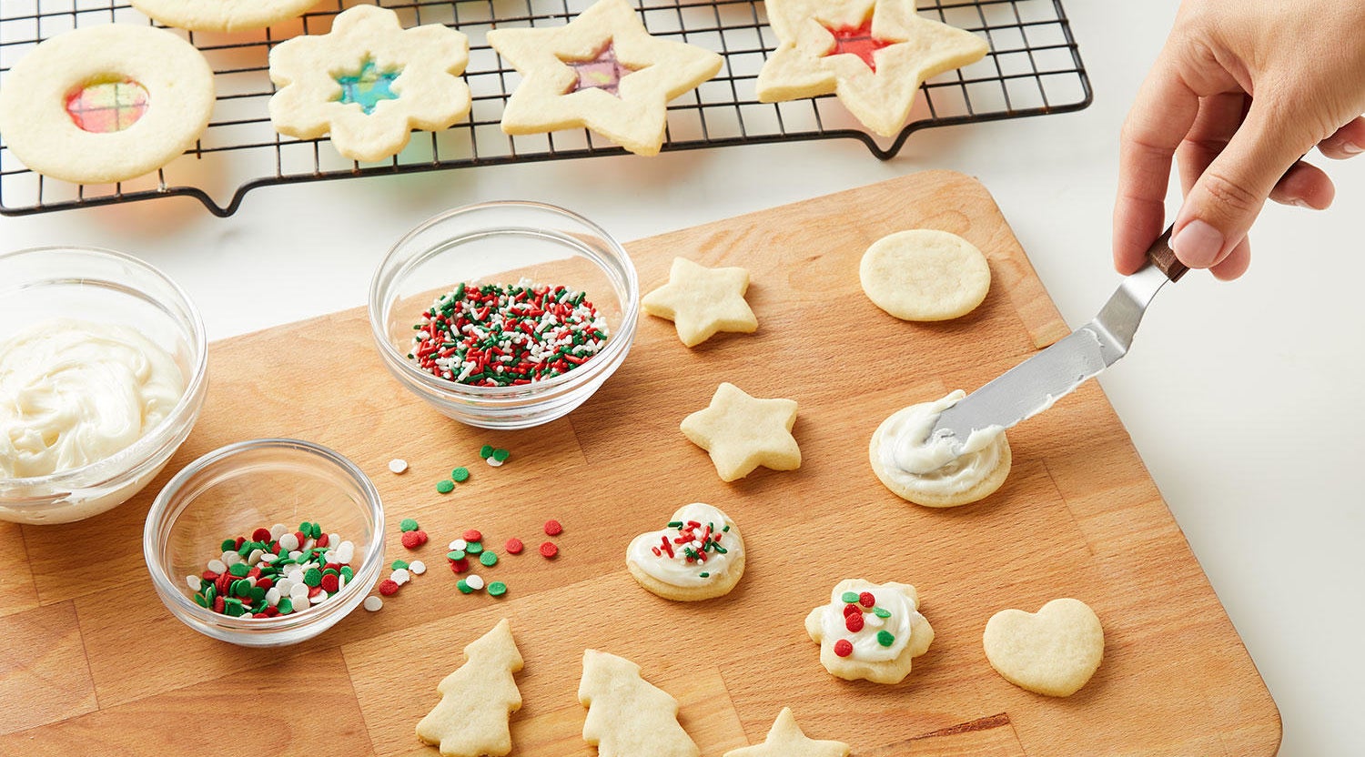 Sugar cookies in different holiday shapes with green and red sprinkles