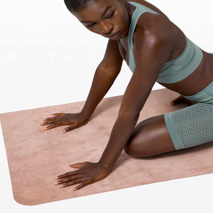 The same model now doing a yoga pose on the mat, showing how it unfolds with no line marks