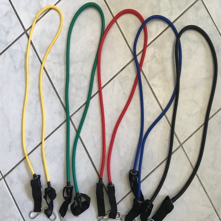 The five resistance bands in yellow, green, red, blue, and black and black handles at either end