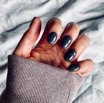 Reviewer with black sparkly nails