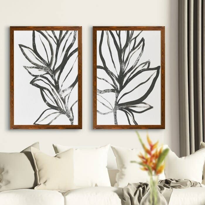 two framed leaf prints hanging over a white couch