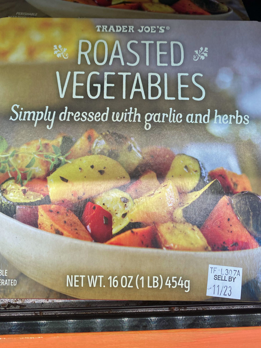 A box of roasted vegetables with garlic and herbs.