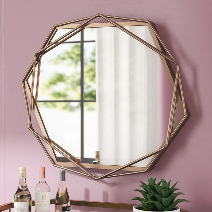 gold accent mirror against a pink mirror