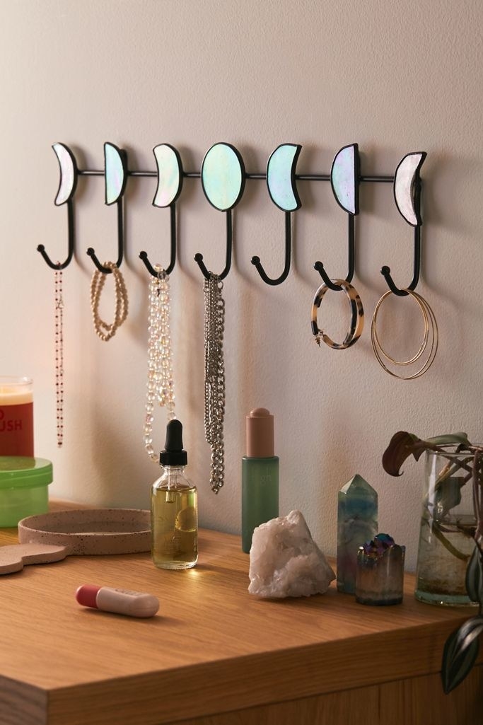 the moon wall hooks with jewelry hanging from the hooks 