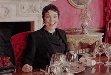 Olivia Colman dancing in a chair