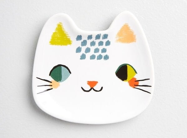 the trinket tray with a cat face painted on it 
