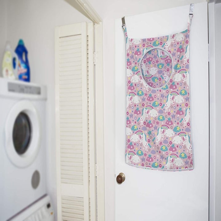 the hamper in unicorn pattern hanging in a laundry room