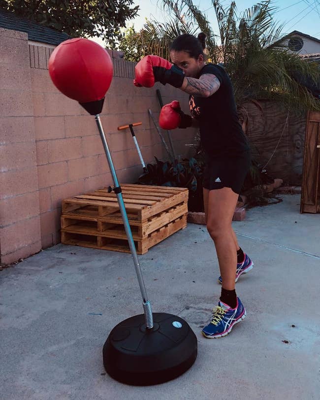 Reviewer with the gloves on their hands punching the bag