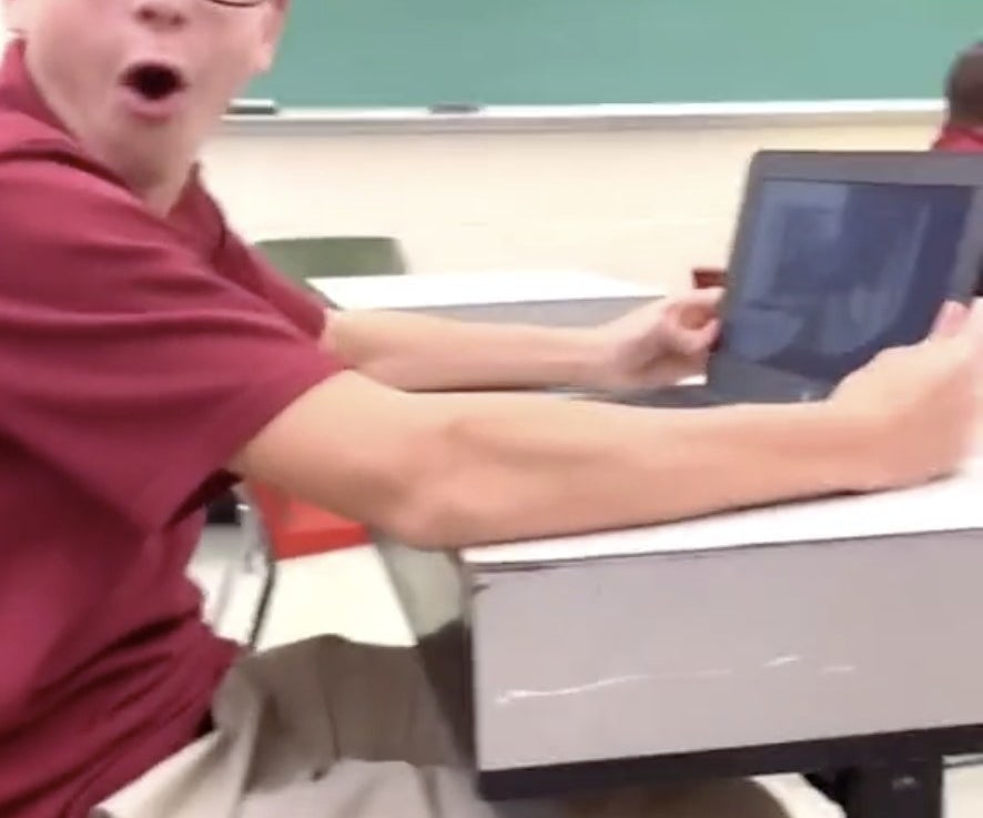 A student gasps while sitting at his desk