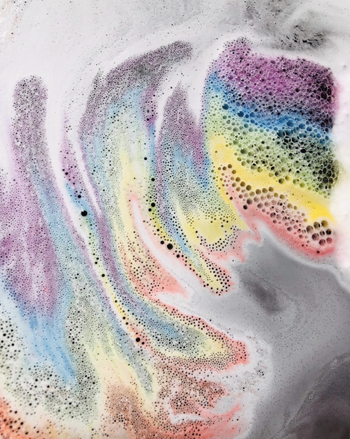 reviewer photo of rainbow soapy water in a bath 