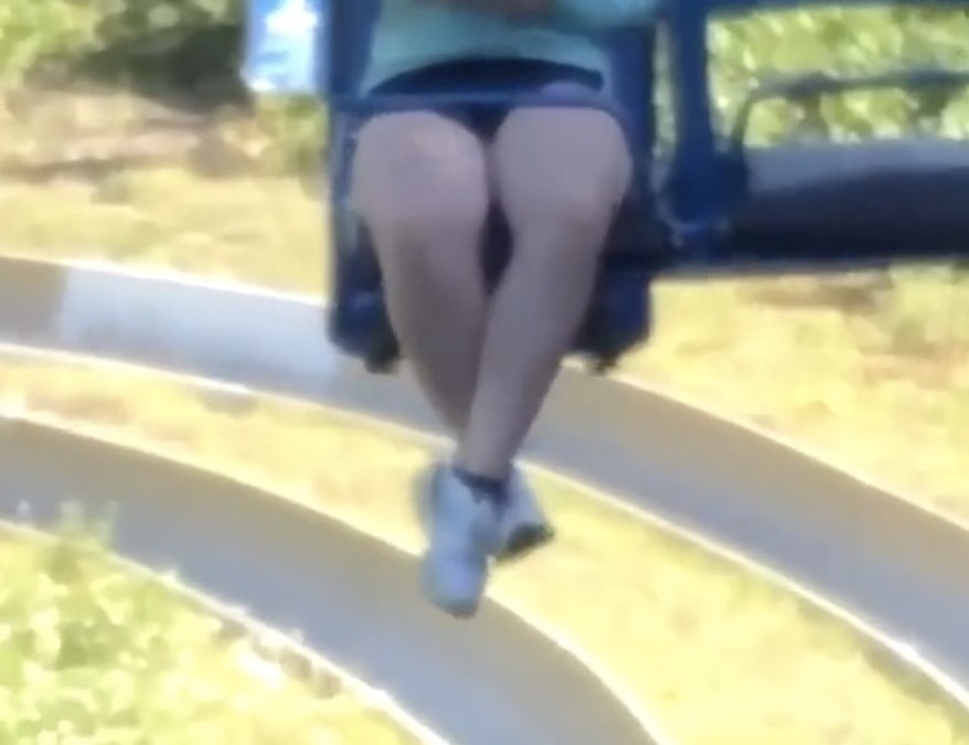 A woman sits on a chairlift with her cell phone in hand