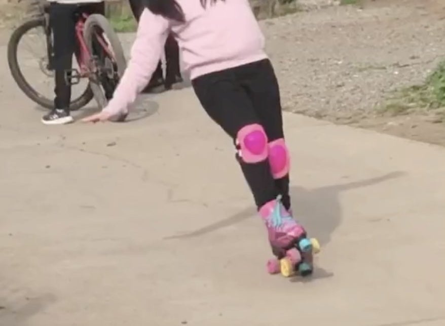 A little girl is about to fall while roller skating