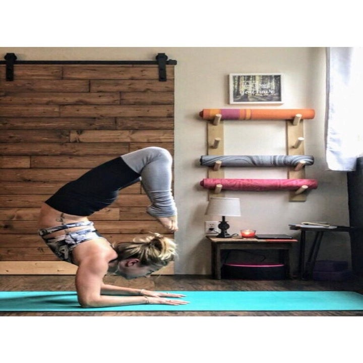 a model doing yoga with the mat holder in the background 