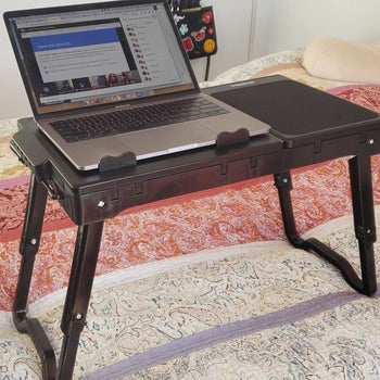 The laptop table sitting on top of a bed