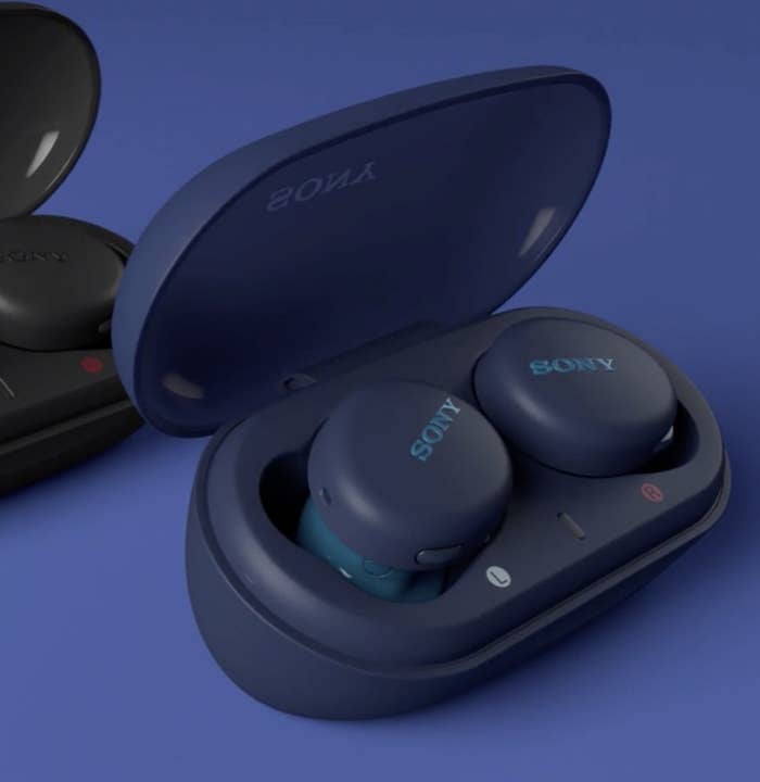 The dark blue earbuds in their charging case