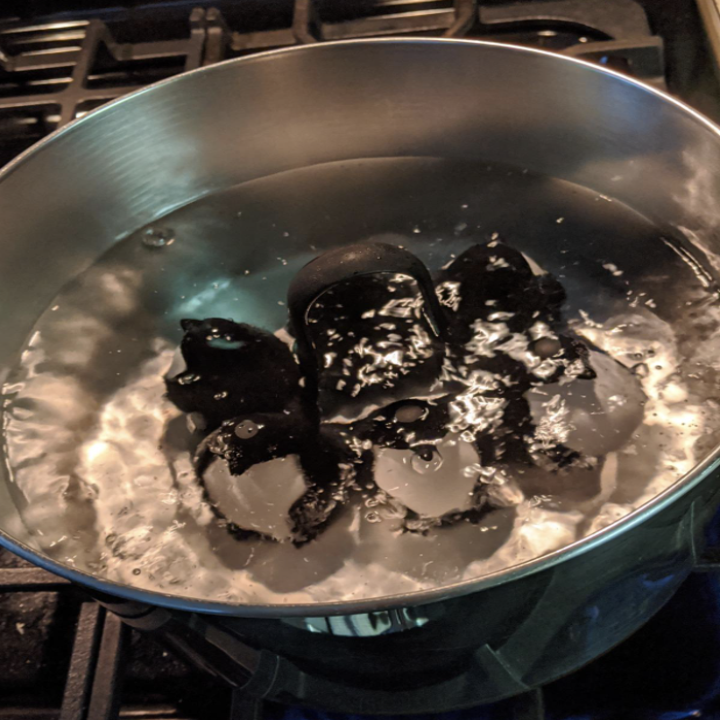 The penguin egg cooker submerged in boiling water