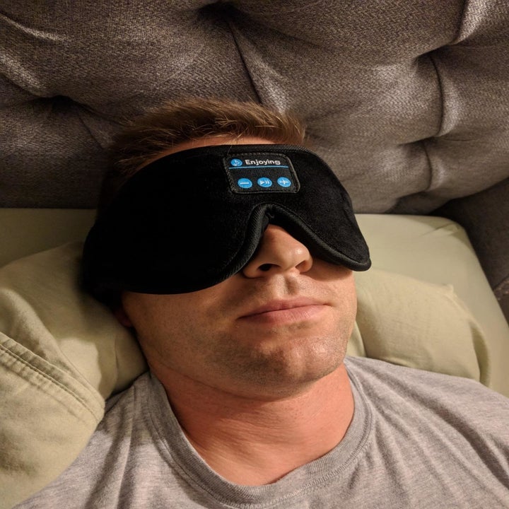 A reviewer wearing the sleep mask
