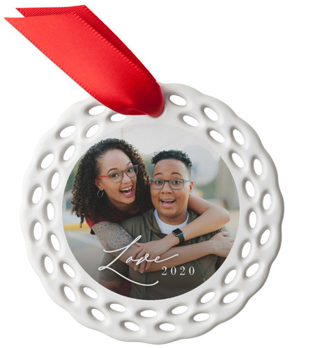 a circular ceramic ornament with tiny oval cut outs around it and a photo of a couple int he middle