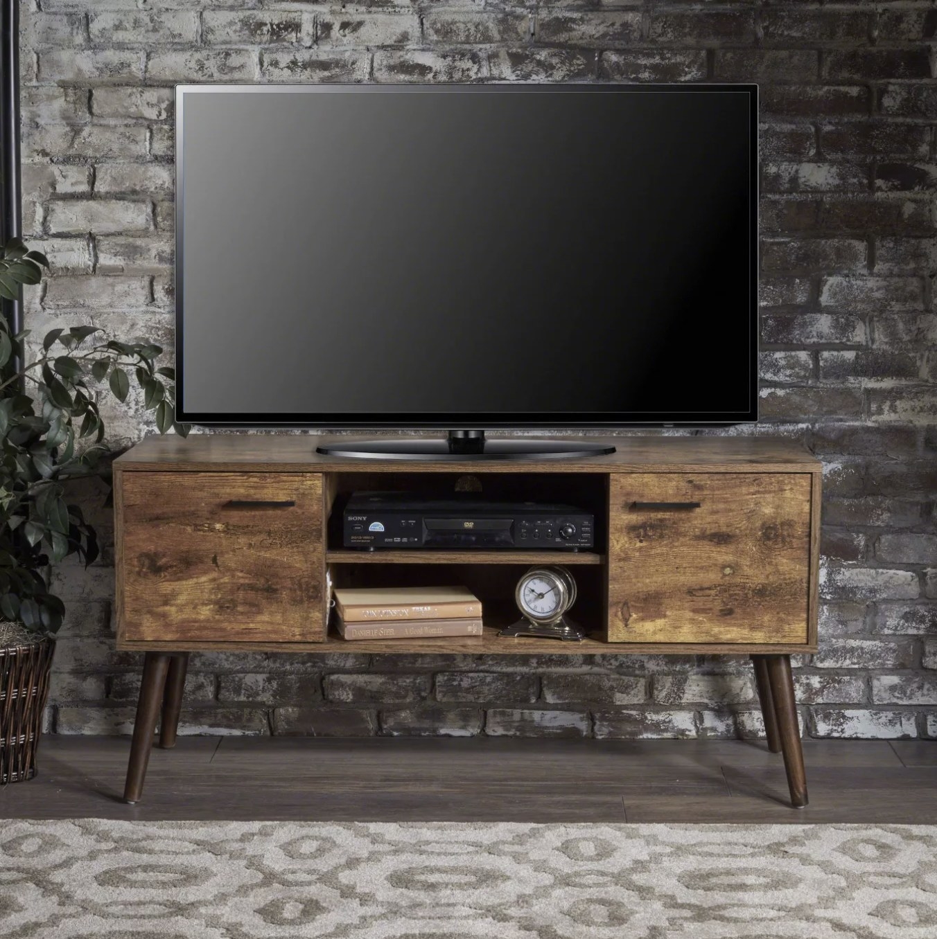 The dark wood entertainment center with a TV on top in a living space