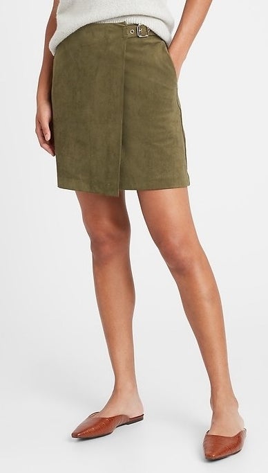 model wearing a green suede wrap mini skirt