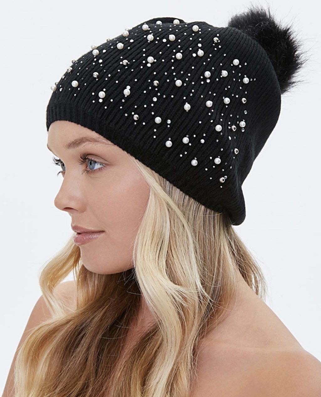 Model is wearing a black pom pom beanie with faux pearls