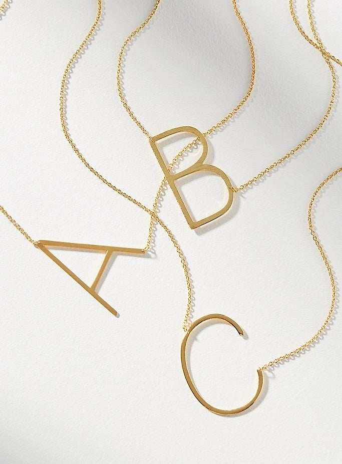 The gold oversized initial necklaces in A, B, and C