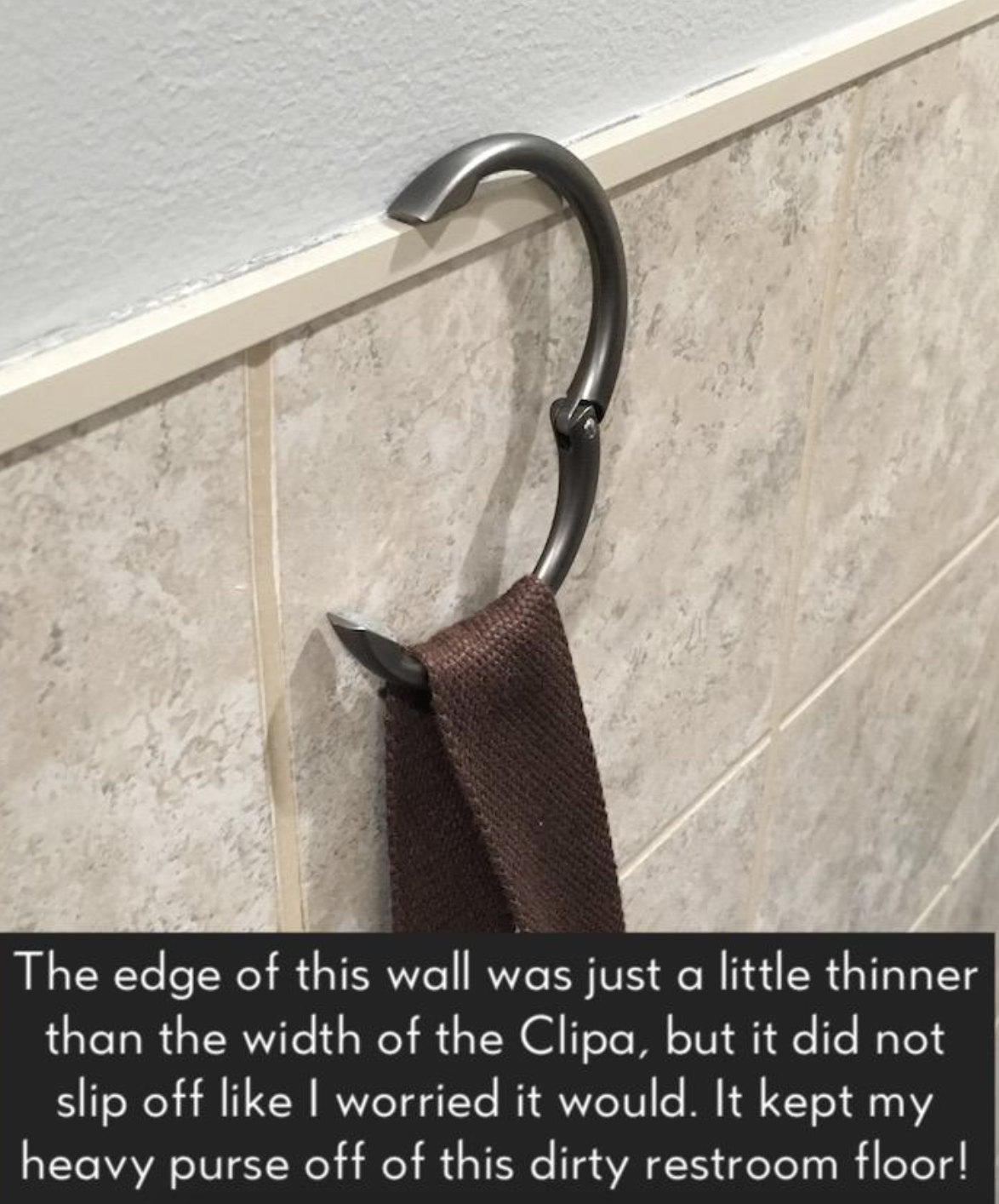 reviewer image of the clip hanging on a thin narrow edge in public restroom, holding a purse