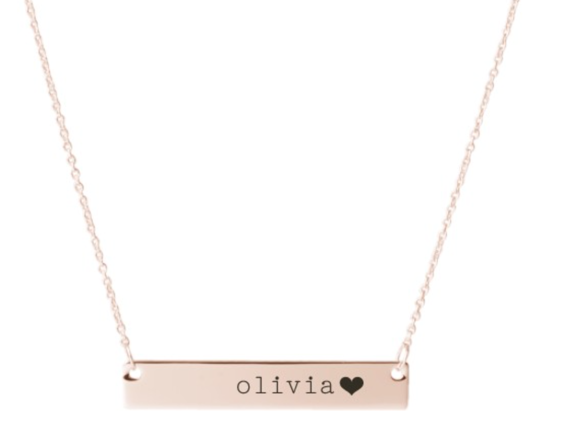 a rose gold necklace with a bar charm with the name olivia and a heart