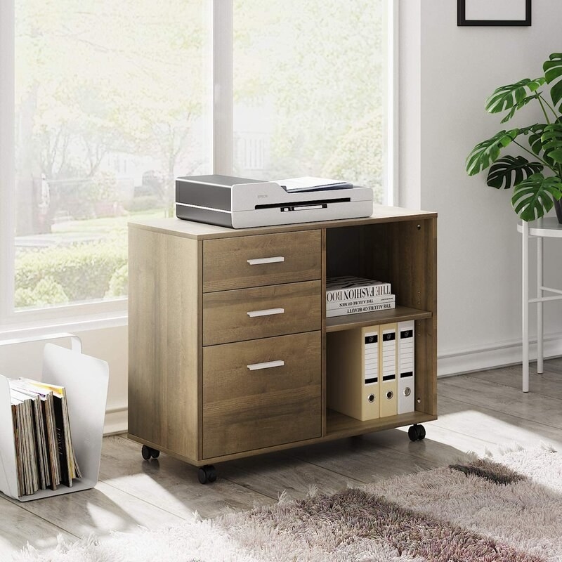 The wooden, rolling filing cabinet with three drawers and two shelves
