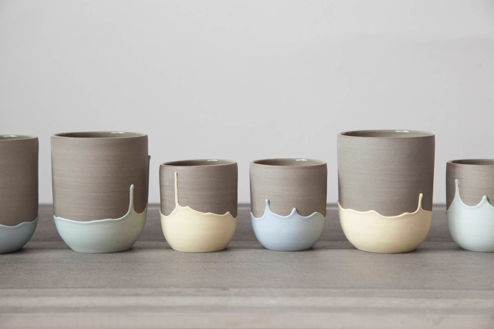 row of six mugs with upside down drip pattern