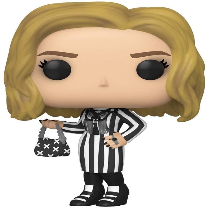 The Moira figure wearing a black and white striped dress and holding a bag that looks like her Prada one