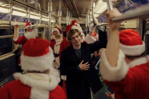 Dash on the subway surrounded by Santas
