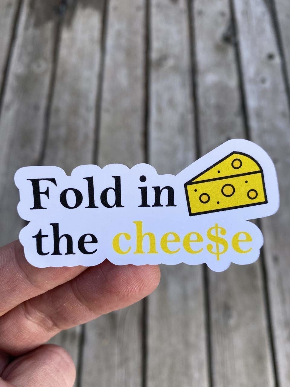 The sticker that reads &quot;Fold in the cheese&quot; with a drawing of cheese