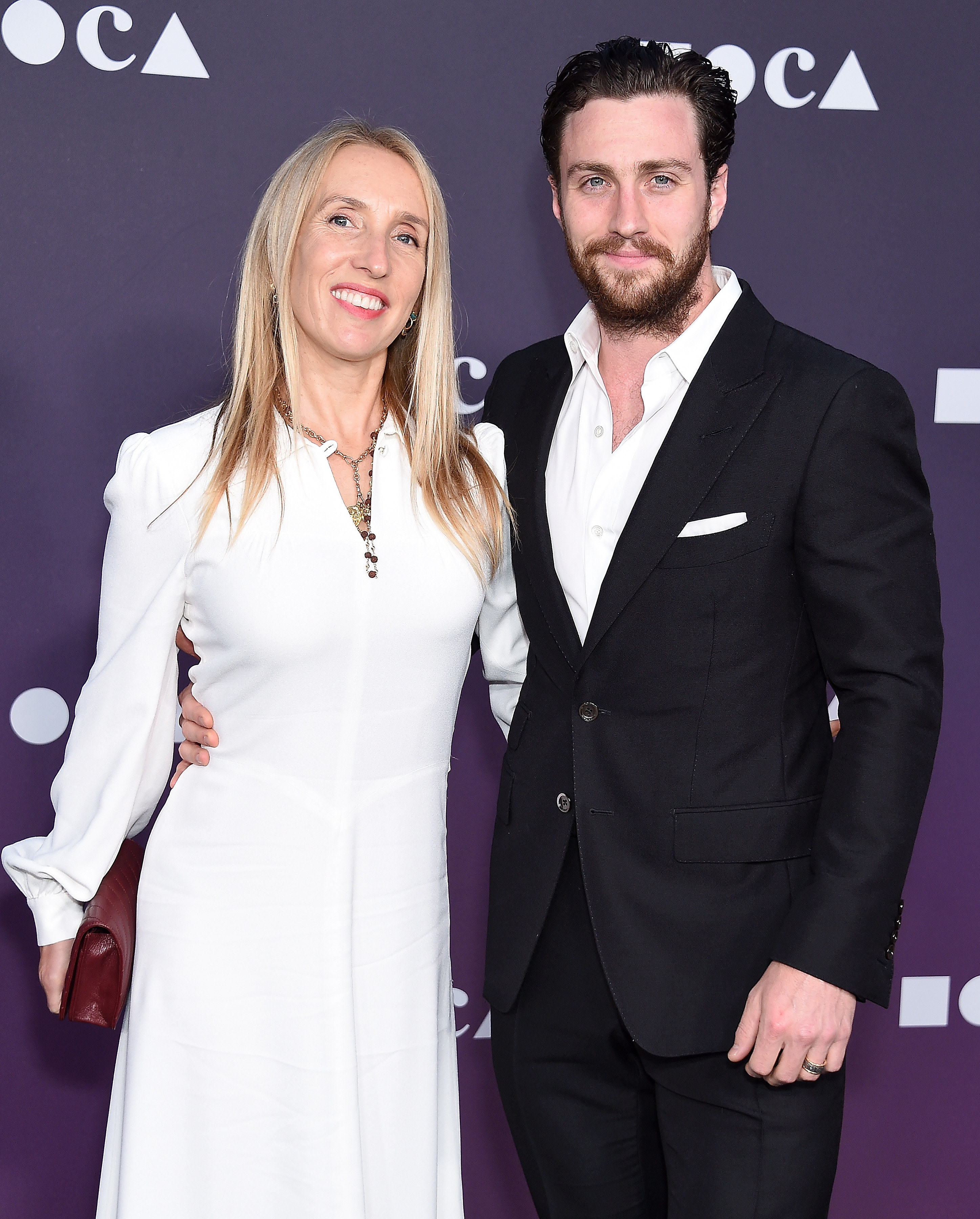 Sam Taylor-Johnson and Aaron Taylor-Johnson smile arm in arm at a film premiere