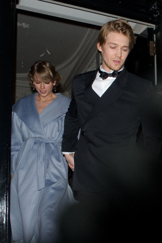 Joe Alwyn holding hands with Taylor Swift as the exit a building