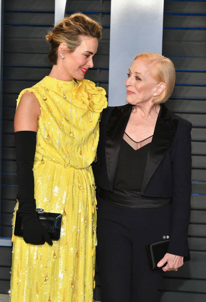 Sarah Paulson in a yellow dress  smiles at Holland Taylor in a black one