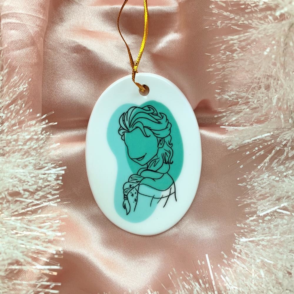 an oval ceramic ornament with a sketch of elsa on it